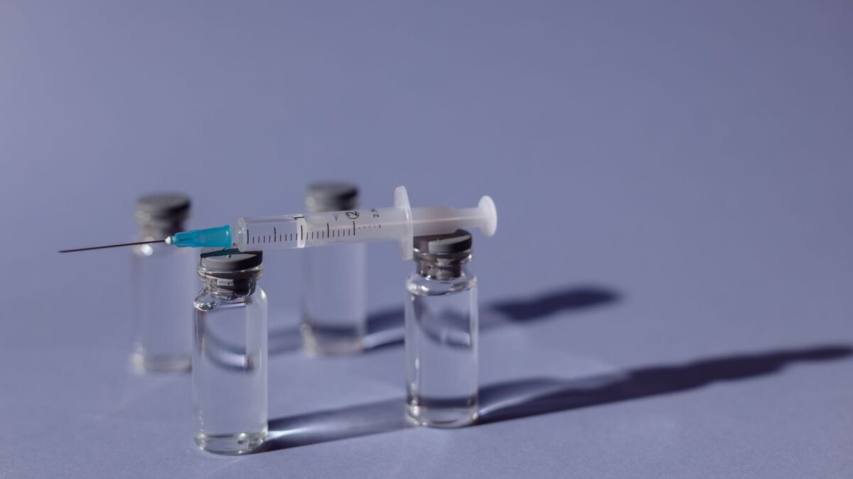 Vacina gripe 2025-2026: frasco da vacina contra influenza sazonal ao lado de um calendário marcando a temporada 2025-2026.