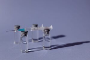 Vacina gripe 2025-2026: frasco da vacina contra influenza sazonal ao lado de um calendário marcando a temporada 2025-2026.