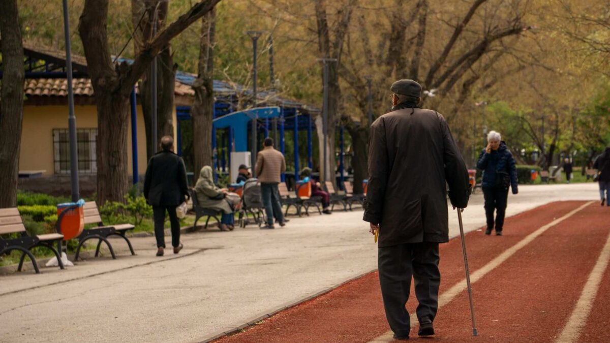 Idosa caminhando rapidamente em parque, representando o conceito de super movers e saúde cerebral.