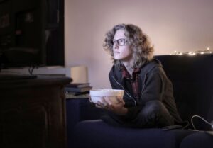 Imagem de uma pessoa sentada e assistindo TV por muito tempo.