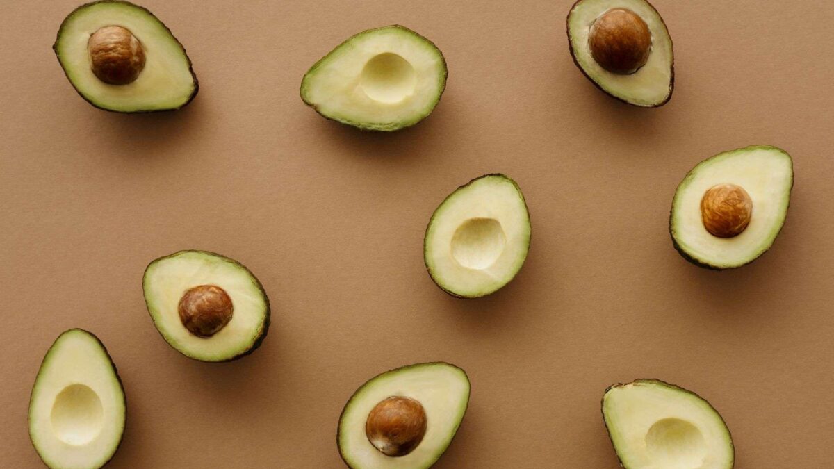 Abacate reduz colesterol ruim: fruta fatiada sobre a mesa, representando alimentação saudável para o coração.