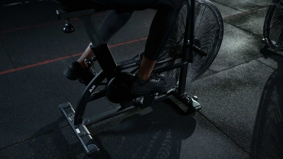 Ciclista em treino intervalado de sprint em bicicleta ergométrica; intensidade do exercício altera proteínas do sangue.