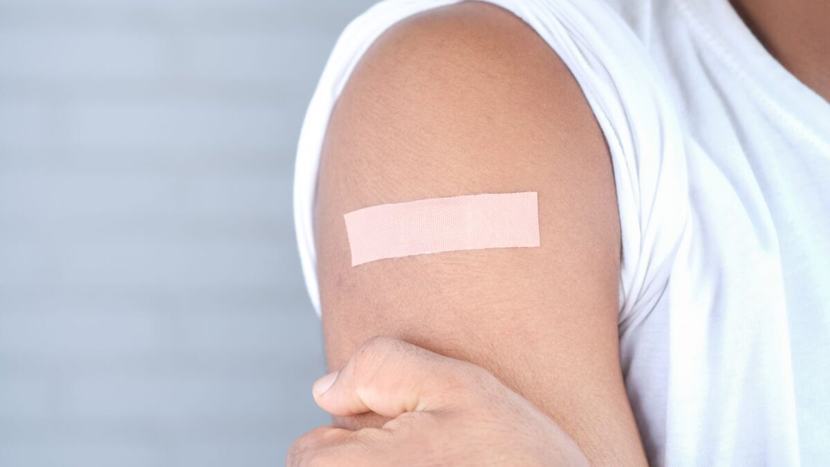 Criança sendo vacinada contra sarampo, caxumba e rubéola com a vacina tríplice viral em uma clínica