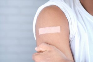 Criança sendo vacinada contra sarampo, caxumba e rubéola com a vacina tríplice viral em uma clínica