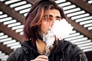 Pessoa usando cigarro eletrônico como alternativa para parar de fumar, segundo revisão Cochrane